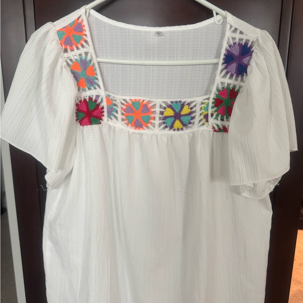 Beautiful flowy summer shirt with crochet pieces along neck border. Perfect with